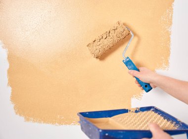 Beyaz bir duvarda şeftali renginde boya paten. Yenileme dairesi. Tamir ve dekorasyon konsepti. Boşluğu kopyala