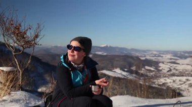 Beautiful woman looks at the sun in the winter mountains. Carpathians. Borzhava. 