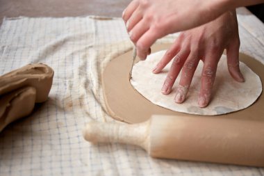 Çömlek atölyesinde çalışan kadın seramik. Seramikçinin Elleri Kirli Çamur. Çömlek yapma süreci. Usta seramist onun stüdyosunda çalışıyor.