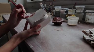 Çömlek atölyesinde çalışan kadın seramik. Seramikçinin Elleri Kirli Çamur. Çömlek yapma süreci. Usta seramist onun stüdyosunda çalışıyor.