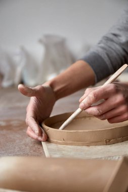 Çömlek atölyesinde çalışan kadın seramik. Seramikçinin Elleri Kirli Çamur. Çömlek yapma süreci. Usta seramist onun stüdyosunda çalışıyor.