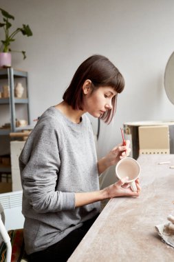 Çömlek atölyesinde çalışan kadın seramik. Seramikçinin Elleri Kirli Çamur. Çömlek yapma süreci. Usta seramist onun stüdyosunda çalışıyor.