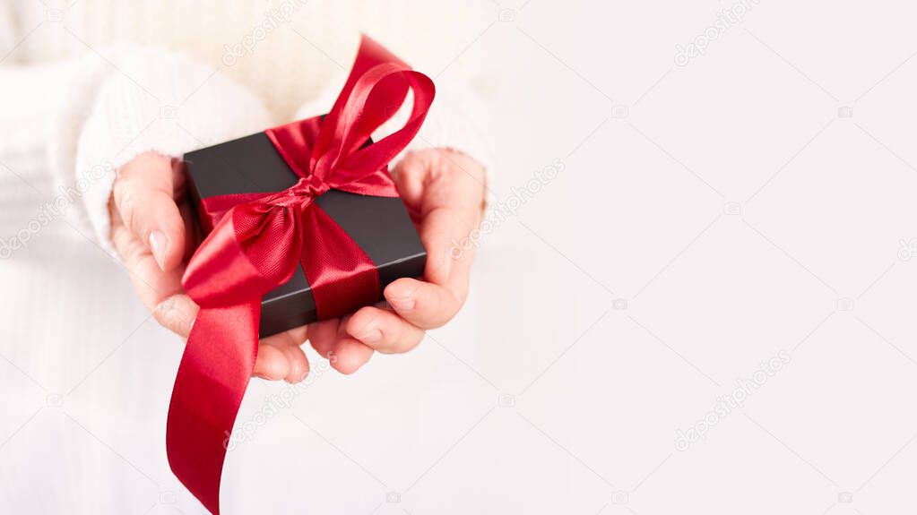 Close up photo of present box in female hands. Woman holding gift box. Valentine's day. Birthday or Holidays concept. Copy space