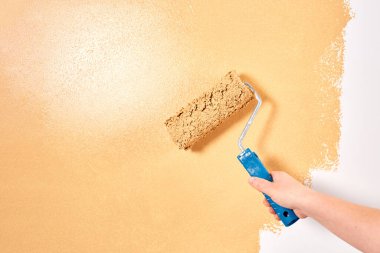 Beyaz bir duvarda şeftali renginde boya paten. Yenileme dairesi. Tamir ve dekorasyon konsepti. Boşluğu kopyala