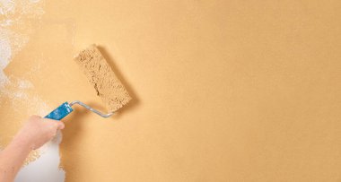 Beyaz bir duvarda şeftali renginde boya paten. Yenileme dairesi. Tamir ve dekorasyon konsepti. Boşluğu kopyala