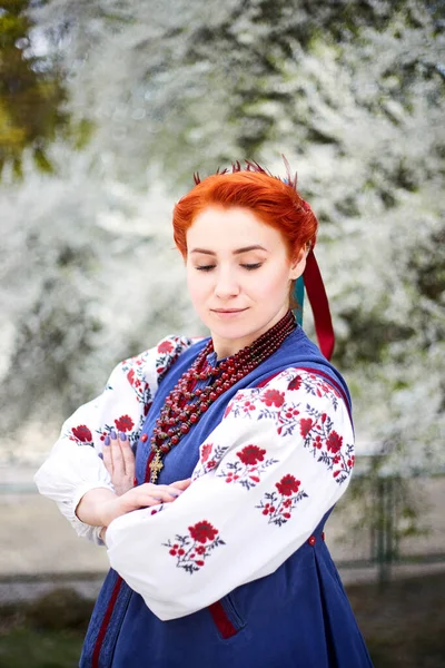 ウクライナ民族衣装の若い女性 伝統的な服で笑顔の若い女性開花木の近くに滞在します ウクライナの平和 — ストック写真