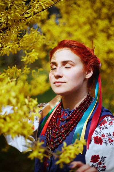 ウクライナ民族衣装の若い女性 伝統的な服で笑顔の若い女性開花木の近くに滞在します ウクライナの平和 — ストック写真