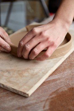 Çömlek atölyesinde çalışan kadın seramik. Seramikçinin Elleri Kirli Çamur. Çömlek yapma süreci. Usta seramist onun stüdyosunda çalışıyor.