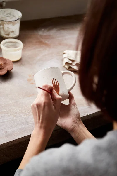 Çömlek atölyesinde çalışan kadın seramik. Seramikçinin Elleri Kirli Çamur. Çömlek yapma süreci. Usta seramist onun stüdyosunda çalışıyor.