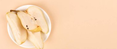 Düz kompozisyon, olgun armutlar, pastel sarı arka plan, üst manzara. Metin için boşluk