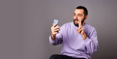 Akıllı telefonu elinde tutan adam video görüşmesi yapıyor. Çevrimiçi iletişim. Video kaydı ya da yaşam çevirisi