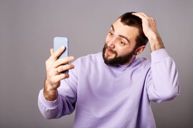 Akıllı telefonu elinde tutan adam video görüşmesi yapıyor. Çevrimiçi iletişim. Video kaydı ya da yaşam çevirisi