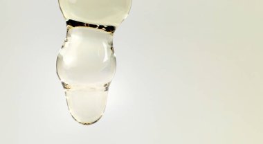 Cam damlacıktan dökülen kozmetik ya da temel yağın makro fotoğrafı. Boşluğu kopyala 