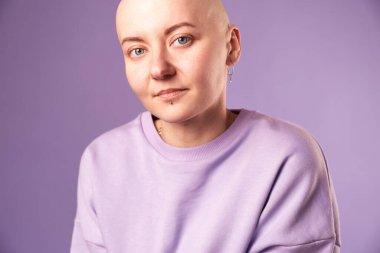 Kanserden muzdarip genç kadın gülüşü gelecekteki iyileşme hakkında olumlu düşünüyor. Milenyum dişisi, kafası kazınmış.