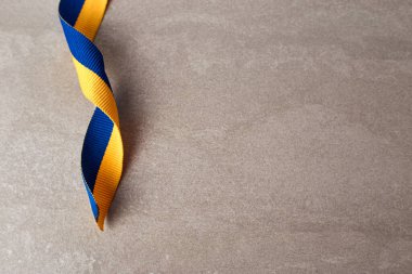 Gri arka planda Ukrayna ulusal bayrağı renkleri. Sarı ve mavi renkli kumaş kurdele. Boşluğu kopyala