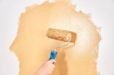 Beyaz bir duvarda şeftali renginde boya paten. Yenileme dairesi. Tamir ve dekorasyon konsepti. Boşluğu kopyala