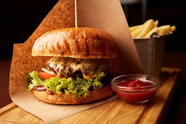 Bardaki ahşap masada patates kızartmalı taze etli burger.