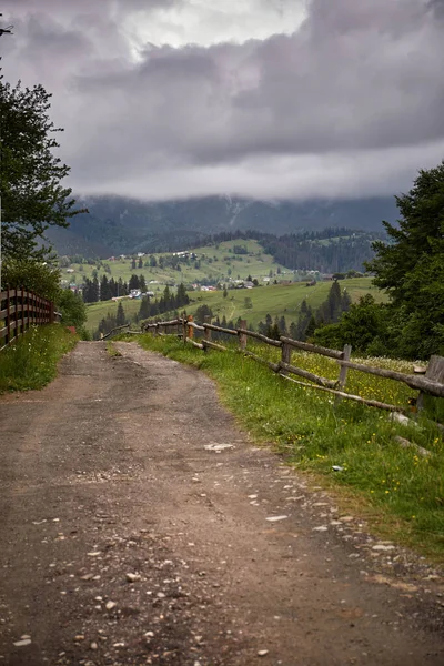 Trail in old Mountain village in the valley. Village in mountains. Rainy day. Summer in Carpathian Mountains. Ukraine