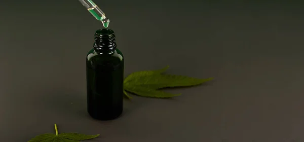 Esrar esaslı petroldür. CBD yağı, marihuana yeşili marihuanayla dolu bir şişe içinde. Tıbbi marihuana. Bitkisel ilaç fabrikası. Metin için boşluk.