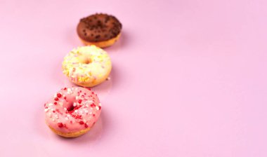 Mor arka planda renkli çörekler. Boşluğu kopyala