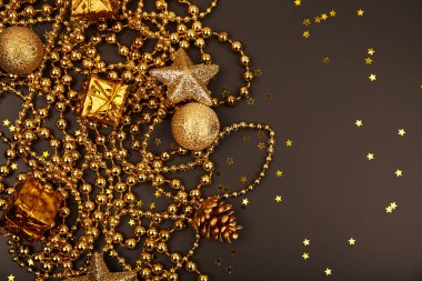 Karanlık arka planda hediye kutuları olan altın Noel süsleri. Tebrik kartı şablonu. Boşluğu kopyala