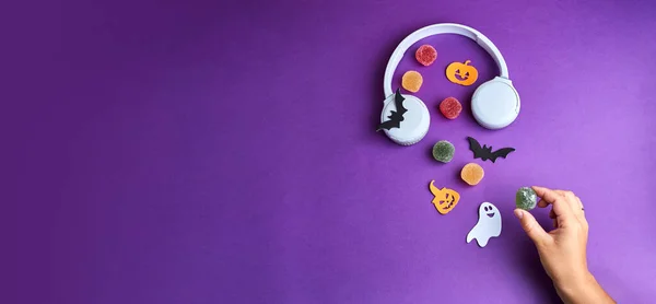 Cadılar Bayramı yayını. Cadılar Bayramı süslemeleri, balkabakları, yarasalar, şekerler, hayaletler, mor arka planda. Cadılar Bayramı partisi tebrik kartı. Uzayı kopyala Düz yatıyordu, üstten, yukarıdan..