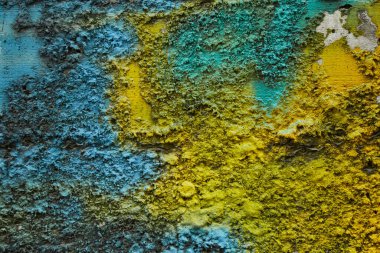 Stone texture painted with colors of ukrainian flag. Blue yellow color stripes paint on rough limestone wall surface