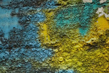 Stone texture painted with colors of ukrainian flag. Blue yellow color stripes paint on rough limestone wall surface