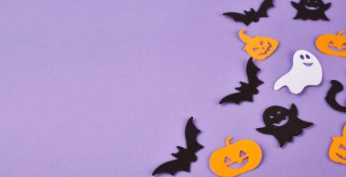 Cadılar Bayramı süslemeleri, balkabakları, mor arka planda. Cadılar Bayramı partisi tebrik kartı. Uzayı kopyala Düz yatıyordu, üstten, yukarıdan..