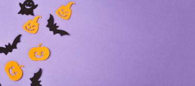 Cadılar Bayramı süslemeleri, balkabakları, mor arka planda. Cadılar Bayramı partisi tebrik kartı. Uzayı kopyala Düz yatıyordu, üstten, yukarıdan..