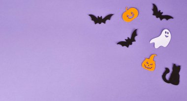 Cadılar Bayramı süslemeleri, balkabakları, mor arka planda. Cadılar Bayramı partisi tebrik kartı. Uzayı kopyala Düz yatıyordu, üstten, yukarıdan..