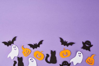 Cadılar Bayramı süslemeleri, balkabakları, mor arka planda. Cadılar Bayramı partisi tebrik kartı. Uzayı kopyala Düz yatıyordu, üstten, yukarıdan..