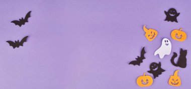 Cadılar Bayramı süslemeleri, balkabakları, mor arka planda. Cadılar Bayramı partisi tebrik kartı. Uzayı kopyala Düz yatıyordu, üstten, yukarıdan..