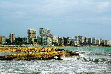 Akdeniz manzarası. Ön planda güzel taştan dalgalar var. İspanya, Alicante, Costa Blanca sahillerindeki yüksek binalarda.