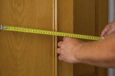 İnşaatçı mezura ile bir nesnenin boyutunu ölçer. Yüksek kalite fotoğraf