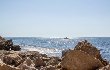 A beautiful view of the mediterranean sea with large stones in the foreground. Campello, Spain.
