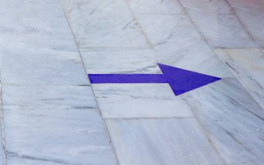 The blue arrow on the marble floor points to the right. High quality photo