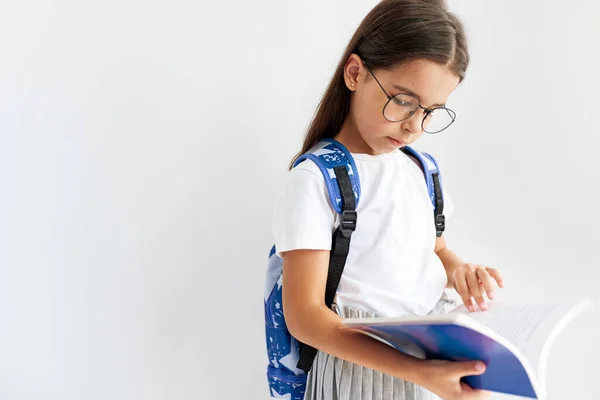 Imagem Estúdio Uma Menina Vestindo Uniforme Óculos Transparentes Lendo Livro — Fotografia de Stock