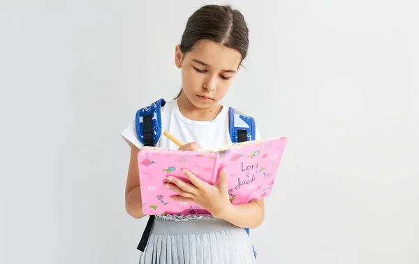 Studio Portrait Schoolgirl Blue Backpack Writes Something Her Pink Notebook Stock Image