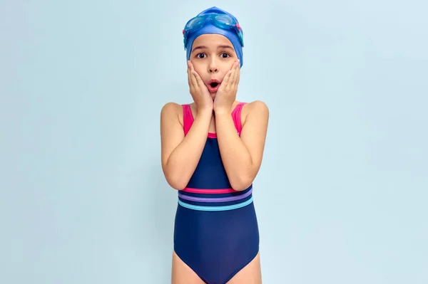 수영용 수영복을 수영용 고글을 모자를 시합을 중놀란 소녀가 스튜디오 배경에 — 스톡 사진