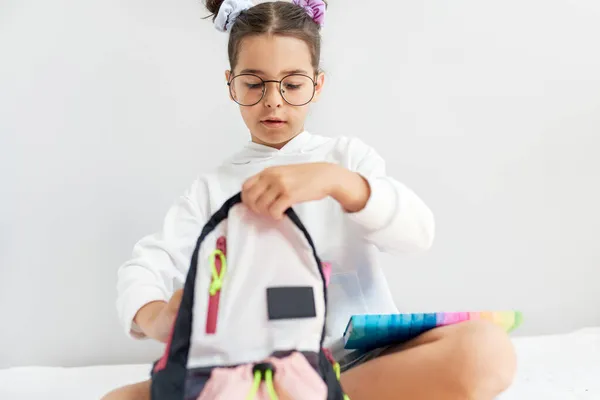 Cute Little Girl Wearing White Hoodie Eyeglasses Preparing Her Backpack Royalty Free Stock Photos