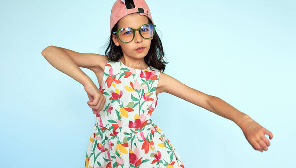 Positive Child Wearing Dress Eyeglasses Pink Cap Dancing Blue Studio Royalty Free Stock Images