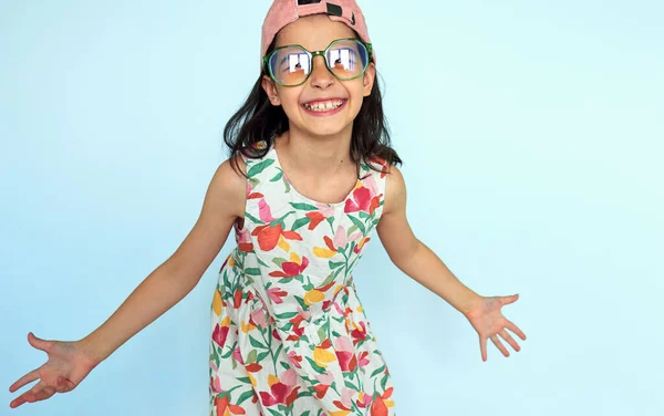 Playful Little Girl Wearing Pink Cap Eyeglasses Colorful Dress Smiling Стоковое Изображение