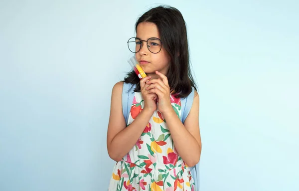 Thoughtful Kid Wearing Colorful Dress Eyeglasees Looking One Side Posing lizenzfreie Stockbilder