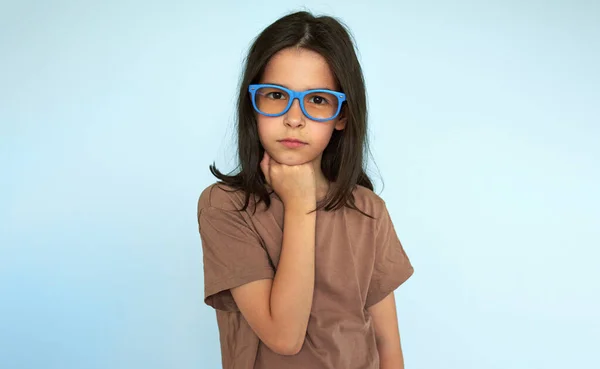 Studio Portrait Serious Kid Wearing Blue Eyeglasees Looking Camera Posing lizenzfreie Stockfotos