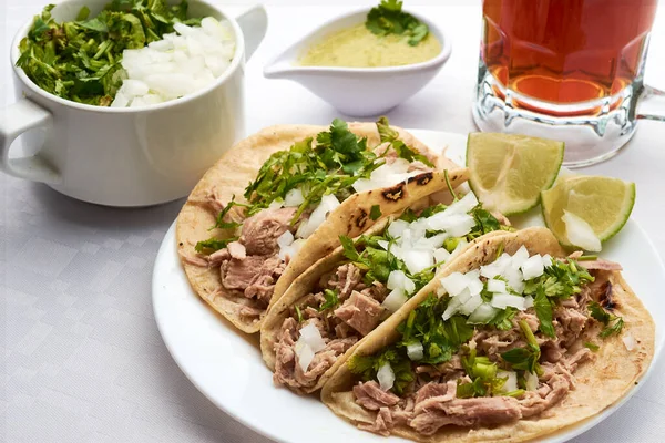 Pork or pork tacos, part that uses the knuckle and corn tortilla, prepared with xalapeo pepper sauce, cilantro and onion.