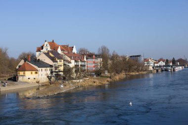 Regensburg, Almanya - 25 Şubat 2021: Regensburg şehir merkezinde Tuna nehrinin kıyısındaki insanlar