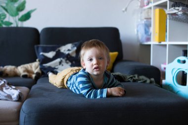 Mavi gözlü, sarı pantolonlu, mavi gözlü bir bebek. Yüksek kalite fotoğraf