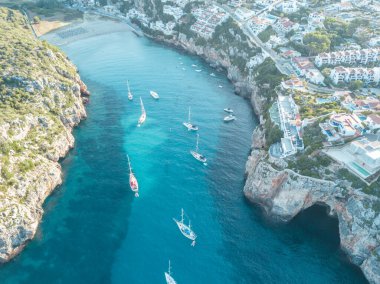 Akdeniz 'de turkuaz safirli sularla dolu tropikal plaja yanaşmış bir teknenin kuş bakışı dronu.
