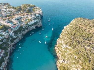 Akdeniz 'de turkuaz safirli sularla dolu tropikal plaja yanaşmış bir teknenin kuş bakışı dronu.